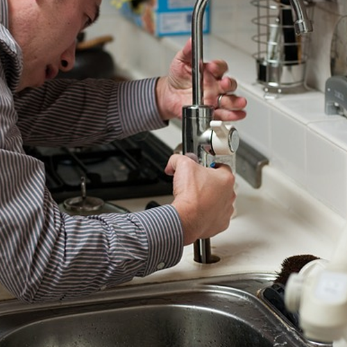 VVS'er er ved at installere en ny vandhane i et køkken